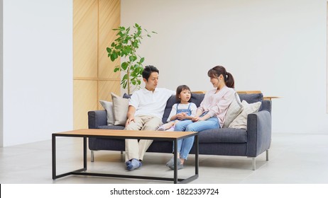 Asian Parents Talking With Their Daughter At Home