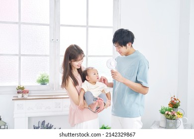 Asian Parents Using The Portable Fan To Their Baby Ash Home