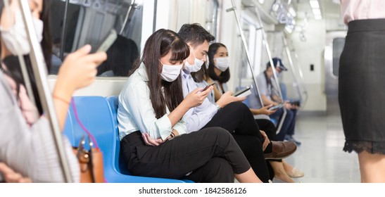 Asian Passenger Wearing Medical Face Mask Playing Smartphone Sitting On Public Subway Seat. New Normal Lifestyle And Social Distancing To Prevent Coronavirus