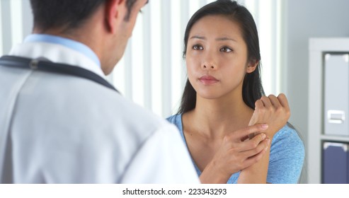 Asian Patient Describing Wrist Pain To Doctor