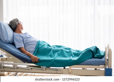 Asian patient man lying down on hospital bed in the hospital room.