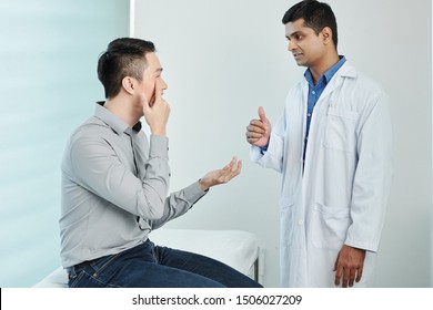 Asian Patient Sitting And Pointing At His Eye And Consulting With Doctor About His Eyesight