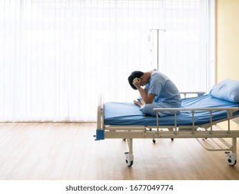 Asian Patient Young Guy Headache From Migraine Disease And Mental Stress While Sitting And Get Intravenous Therapy From Professional Doctor And Nurse On Hospital Bed Admit In Clean Room 