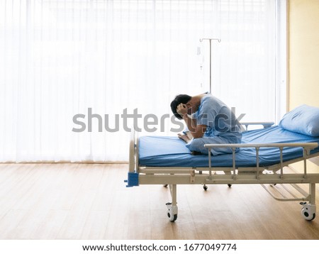 Asian patient young guy headache from migraine disease and mental stress while sitting and get intravenous therapy from professional doctor and nurse on hospital bed admit in clean room 