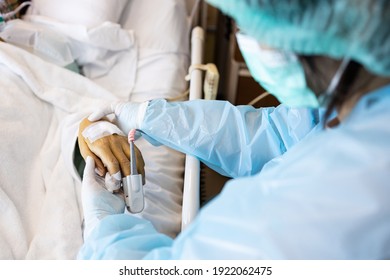 Asian Patient's Hand With An Attached Pulse Oximeter On Finger For Monitoring,daughter Holding Mother's Hand,look After Elderly In A Coma,seriously Ill Patient,intensive Care In ICU Room At Hospital