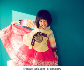 Asian people concept.Smile Korean little girl wearing a Traditional Hanbok dress in blue background - Powered by Shutterstock