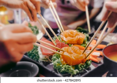 Asian People Eating Sashimi Set In Asian Restaurant