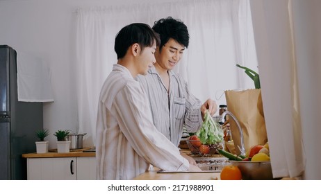 Asian People Happy Time Smile, Laugh In Kitchen. Best Friend LGBTQ Lifestyle. Happy Asian Gay Couple Cooking Together In Kitchen Prepare Fresh Vegetable Make Organic Salad Healthy Food.