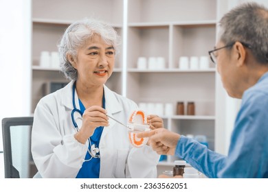 Asian people mature dentist having a compassionate conversation with elderly patient, discussing oral health results, providing expert advice and detailed dental report. Dental Guidance - Powered by Shutterstock