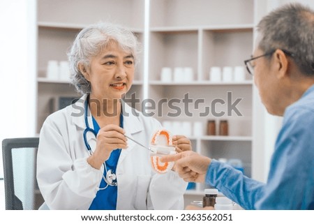 Asian people mature dentist having a compassionate conversation with elderly patient, discussing oral health results, providing expert advice and detailed dental report. Dental Guidance