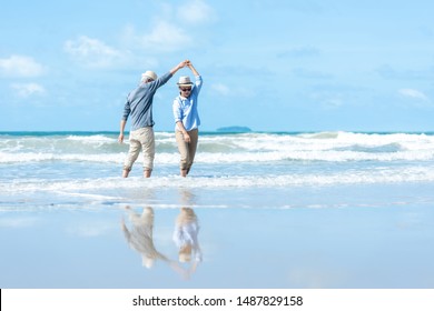 Asiatisches Lifestyle-Senior-Paar tanzt am Strand glücklich und entspannt Zeit.  Tourismus ältere Familien reisen Freizeit und Aktivität nach dem Ruhestand in Urlaub und Sommer.