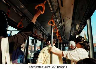 Asian people standing inside the city bus. Public transport is fully crowd after work hours. - Powered by Shutterstock