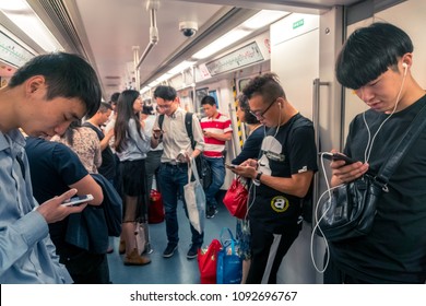 Asian People Staring At Smartphone Inside Train In Shenzhen, China - April 2018