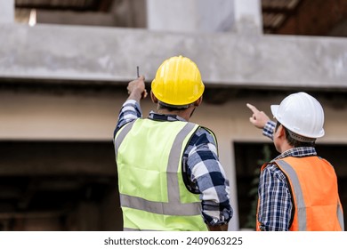 Asian people, two man, holding blueprints Structural engineers examine structural plans for office buildings and housing developments on-site, discussing work at construction site. - Powered by Shutterstock