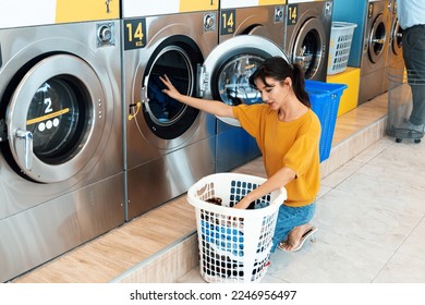 Asian people using qualified coin operated laundry machine in the public room to wash their cloths. Concept of a self service commercial laundry and drying machine in a public room.