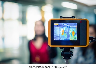 Asian people waiting for body temperature check before access to building for against epidemic flu covid19 or corona virus from wuhan in office by thermoscan or infrared thermal camera - Shutterstock ID 1688350552
