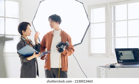 Asian Photographer And Director Talking In The Shooting Studio.