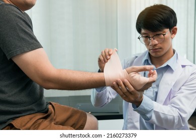 Asian Physiotherapists Are Examining The Results Of Wrist Surgery Of Patients.