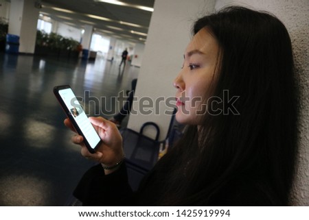 Young woman browsing on smartphone while seated on couch