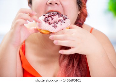 asian plus size woman eat a donut happily