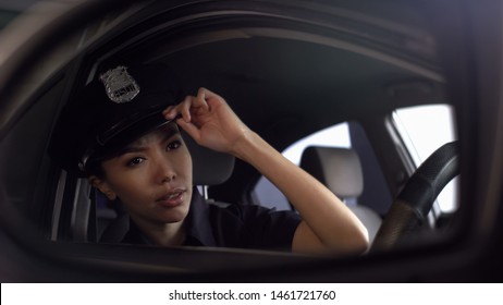 Asian Police Officer Adjusting Her Uniform Cap Looking Into Rearview Mirror