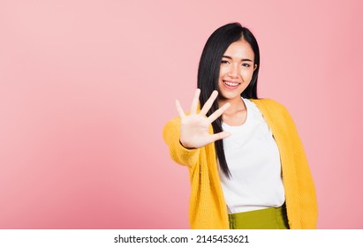 Asian Portrait Beautiful Cute Young Woman Teen Smiling Doing Show Stop Sign Gesture With Palm Of Hand But Happy Face Studio Shot Isolated On Pink Background, Female Doubt With Copy Space