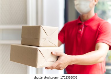 Asian Postman, Deliveryman Wearing Mask Carry Small Box Deliver To Customer In Front Of Door At Home. Man Wearing Mask Prevent Covid19, Corana Virus Affection Outbreak. Social Distancing Work Concept.