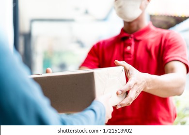 Asian Postman, Deliveryman Wearing Mask Carry Small Box Deliver To Customer In Front Of Door At Home. Man Wearing Mask Prevent Covid19, Corana Virus Affection Outbreak. Home Delivery Shopping Concept.