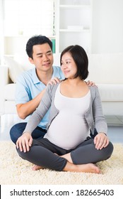 Asian Pregnant Couple Giving Massage To Wife