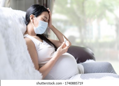 Asian Pregnant Woman Is Checking Body Temperature For Symptom Of Fever, Headache Of Viral Infection, Concept Of Sickness And Healthcare In Pregnancy In The Situation Of Covid 19 Outbreak.