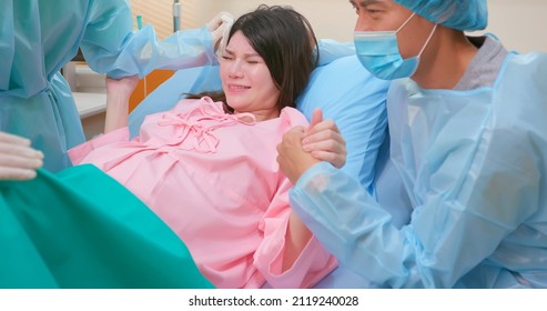 Asian Pregnant Woman In Delivery Room Is Preparing To Give Birth And Husband Is Comforting Her In Hospital