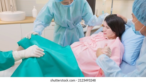 Asian Pregnant Woman In Delivery Room Is Preparing To Give Birth And Husband Is Comforting Her In Hospital