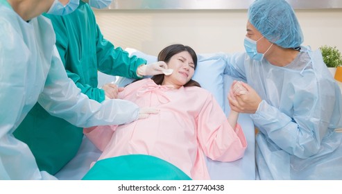 Asian Pregnant Woman In Delivery Room Is Preparing To Give Birth And Husband Is Comforting Her In Hospital