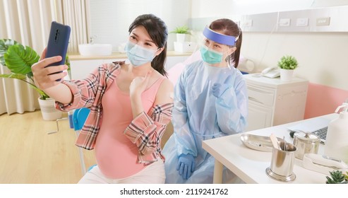 Asian Pregnant Woman And Female Doctor Wearing Face Mask Take Selfie By Mobile Phone After Receiving Coronavirus Vaccine