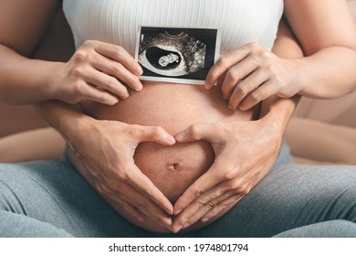 Asian pregnant woman and husband  holding hand together, holding ultrasound scan image and making hand heart gesture on her belly,  Expectation of child and woman pregnancy concept. - Powered by Shutterstock