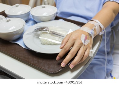 Asian Pregnant Woman Patient Is On Drip Receiving A Saline Solution With Cooked Rice And Other Food In White Bowl , Selective Focus.