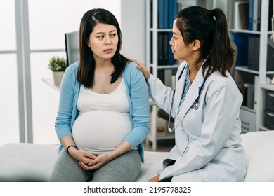 asian pregnant woman suffering depression is looking at her psychologist doctor who is patting on her shoulder showing support during consultation in the clinic - Powered by Shutterstock