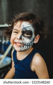 Asian Preschooler Doing Skeleton Face Paint In The Outdoor Ready For Carnival. Halloween Party In Outdoors. Long Haired Kid With Blue Shirt. Cheerful Child Ready For Festival. Activity For Children.