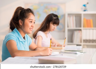 Asian preteen schoolgirls writing test in classroom - Shutterstock ID 278120729