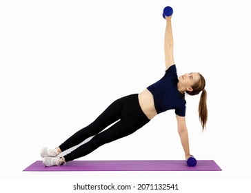 Asian Pretty Sport Woman In Black Sportwear Pigtail Hair Lifting Dumbbell And Stretching On The Purple Yoga Mat On The White Background.