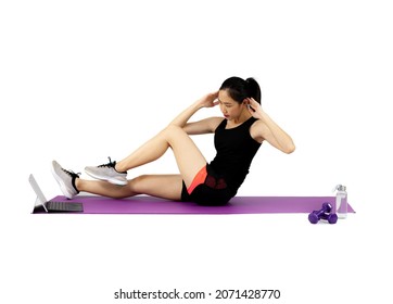 Asian Pretty Sporty Woman In Black Sportwear Stretching On The Purple Yoga Mat On The White Background With Dumbbell And Water Bottle.