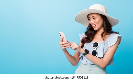 Asian pretty woman tourist preparing for travel and using smartphone isolated on blue banner background.Concept of people using technology of travel. - Powered by Shutterstock