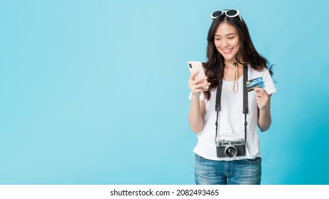 Asian Pretty Woman Tourist Preparing For Travel And Shopping Online With Smartphone And Credit Card Isolated On Blue Banner Background.Concept Of People Using Technology Of Travel.