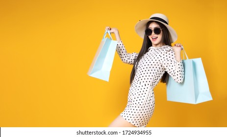 Asian Pretty Young Woman  On Yellow Colour Background. She Smiling And  Happy Shopping Bags. She Nice-looking Lovely Attractive Shine .Summer Sale Colourful Happy Time.