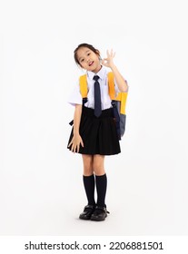 Asian primary school student kid in uniform with yellow backpack posing on white background. Back to school concept. - Shutterstock ID 2206881501