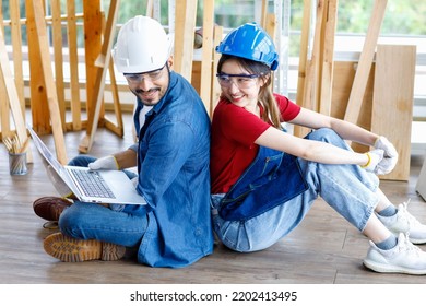 Asian Professional Female And Indian Bearded Male Engineer Architect Foreman Labor Worker Wear Safety Goggles And Gloves Sitting On Floor Smiling Working With Laptop Computer Discussing Together.