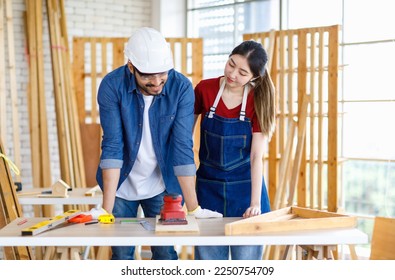 Asian professional female and Indian bearded male engineer architect foreman labor worker lover couple wear safety hard helmet jeans apron and gloves standing smiling together in construction site.