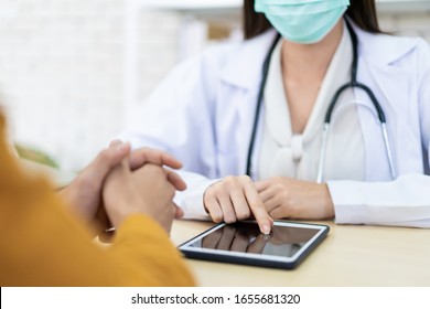 Asian professional specialist doctor explaining and talking about influenza virus diagnostic result to patient at doctor office in general hospital by using touchscreen tablet.