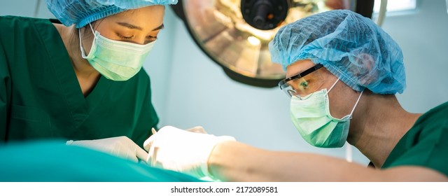 Asian Professional Surgeons Team Performing Surgery In The Operating Room, Surgeon, Assistants, And Nurses Performing Surgery On A Patient, Health Care Cancer And Disease Treatment Concept