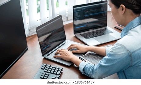 Asian Programmer Woman Looking On Multiple Computer Screen To Typing Coding Database And Development Website Or Applications While Working About New Project In Software Development Office